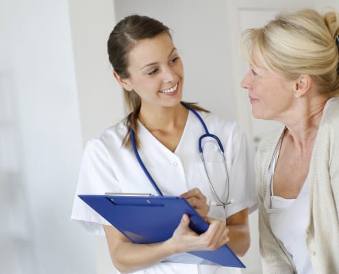 Nurse giving presciption to elderly woman